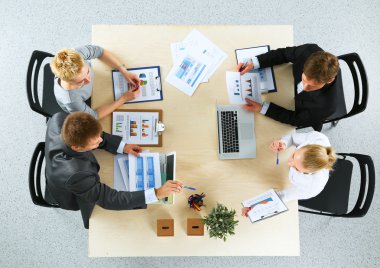 İş adamları iş toplantısında, ofiste oturup tartışıyorlar.