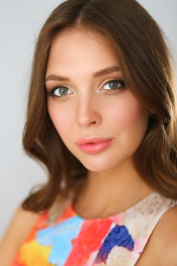 Beyaz arka planda poz veren güzel bir kadın.