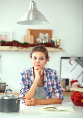 Genç kadın evde mutfak dergi okuma