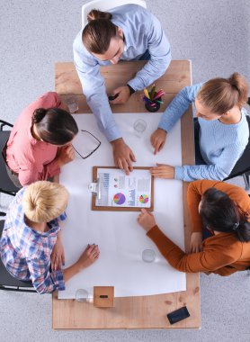 İş adamları iş toplantısında, ofiste oturup tartışıyorlar.