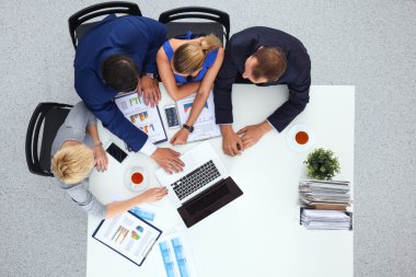 İş adamları iş toplantısında, ofiste oturup tartışıyorlar.