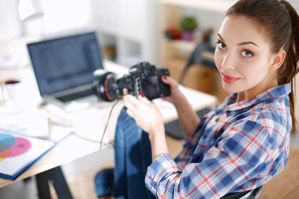 Fotografka sedící na stole s laptopem — Stock fotografie