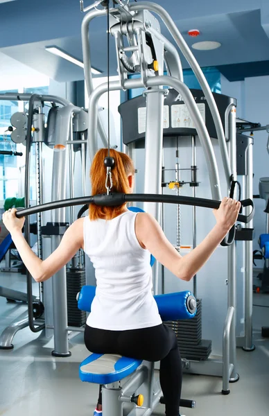 Hermosa chica en el gimnasio haciendo ejercicio en los entrenadores — Foto de Stock