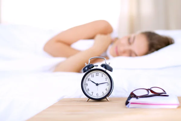 Una hermosa joven acostada en la cama cómoda y felizmente — Foto de Stock