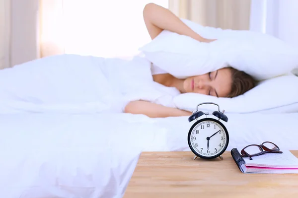 Une jeune femme éteint son réveil le matin — Photo