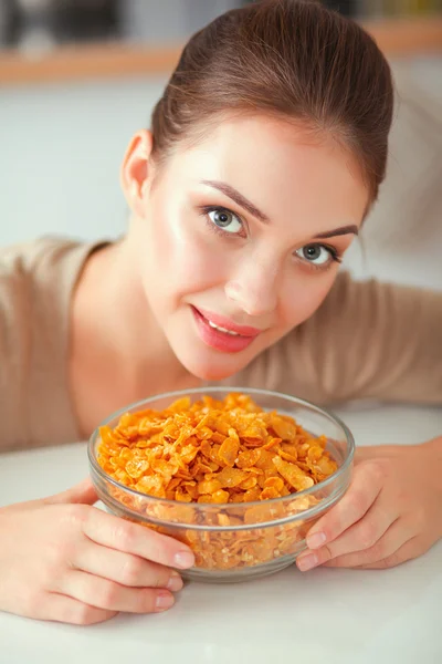 Sorrindo mulher atraente tomando café da manhã no interior da cozinha — Fotografia de Stock