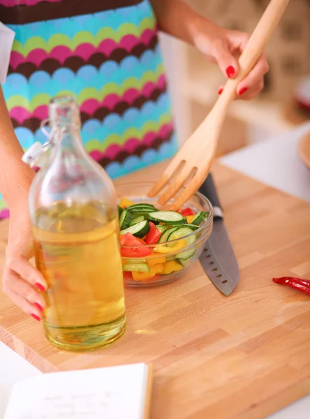 Glimlachende jonge vrouw mengen van verse salade — Stockfoto