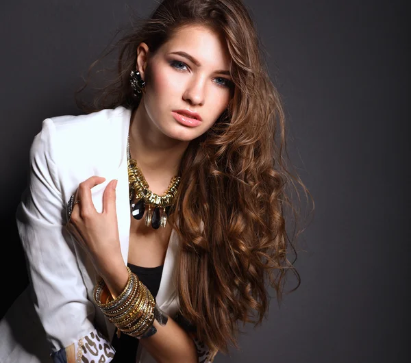 Young beautiful brunette woman  jewelry on grey background — Stock Photo, Image