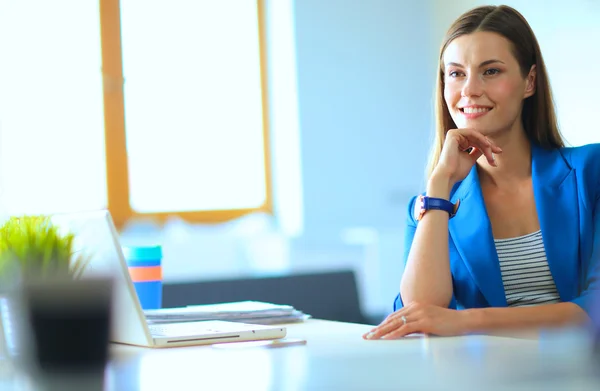 Mujer sentada en el escritorio con portátil — Foto de Stock