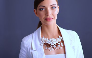 Boncuklar, gri arka plan üzerinde duran genç kadın portresi