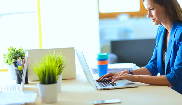 Woman sitting on the desk with laptop — Stock Photo, Image