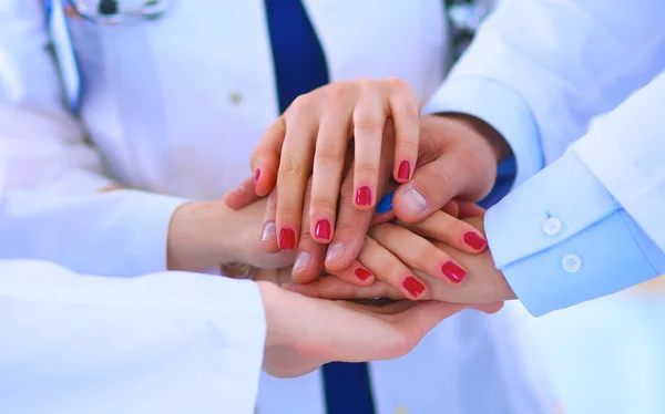 Médicos y enfermeras en un equipo médico apilándose las manos — Foto de Stock