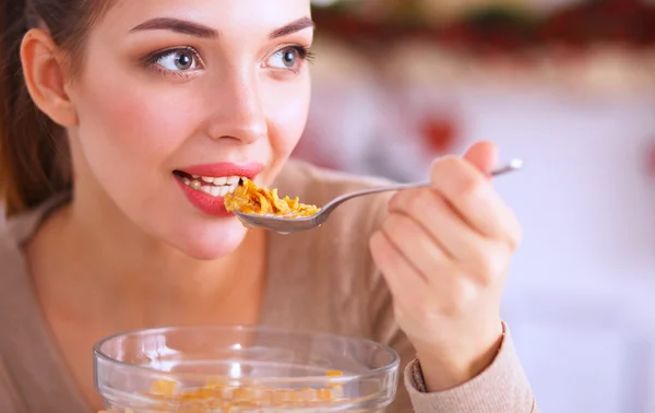 Mujer atractiva sonriente desayunando en el interior de la cocina — Foto de Stock