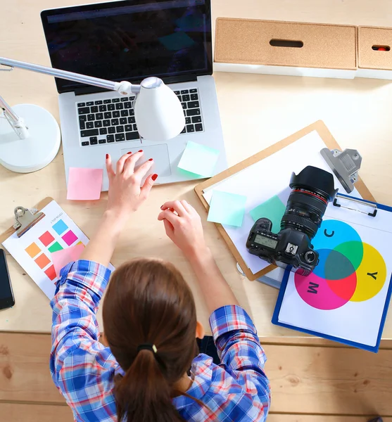 Femme photographe assise sur le bureau avec ordinateur portable — Photo