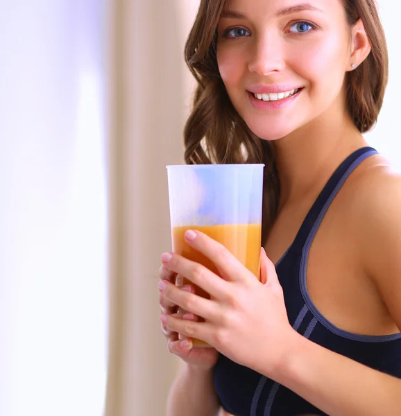 Flicka sitter i köket på skrivbord med frukt och glas med juice — Stockfoto