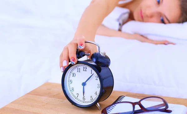 Молодая женщина откладывает будильник на утро — стоковое фото