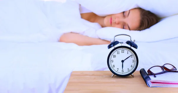 Eine junge Frau stellt morgens ihren Wecker aus — Stockfoto