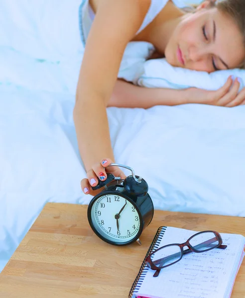 Une jeune femme éteint son réveil le matin — Photo