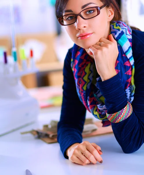 Beautiful fashion designer sitting at the desk in studio — Stock Photo, Image