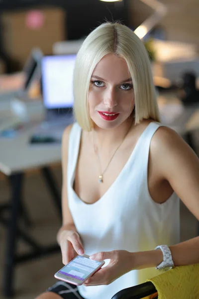 Mujer diseñador usando en el teléfono móvil en la oficina — Foto de Stock