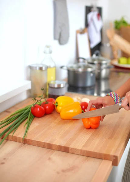 Jonge vrouw snijden groenten in de keuken — Stockfoto