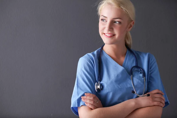 Young doctor woman with stethoscope isolated on gray background Stock Picture