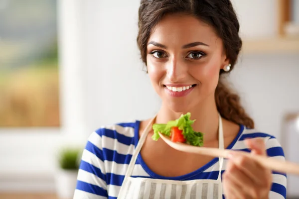 Giovane donna mangiare insalata fresca in cucina moderna — Foto Stock