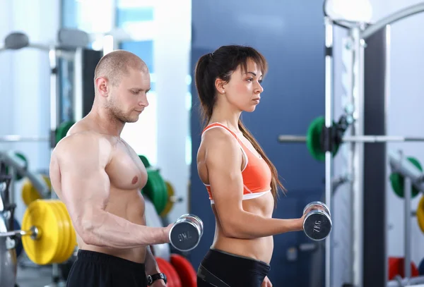 Schöne Frau im Fitnessstudio beim Training mit ihrem Trainer — Stockfoto