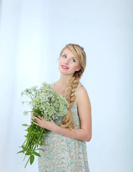 Mujer feliz de pie en blanco con flores, aislado en blanco — Foto de Stock