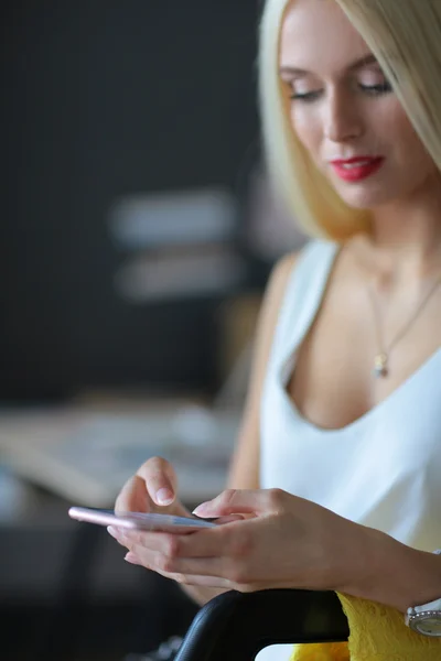 Mujer diseñador usando en el teléfono móvil en la oficina — Foto de Stock