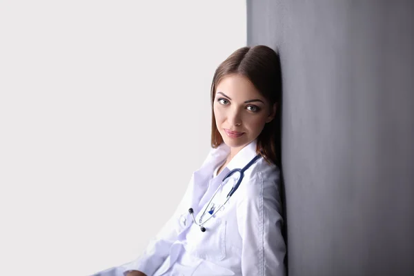 灰色の背景に隔離された聴診器を持つ医師の女性 — ストック写真
