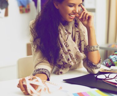 Stüdyoda çalışan genç moda tasarımcısı.