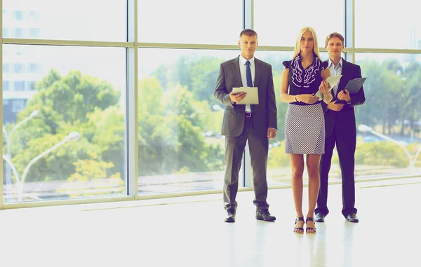 Femeie de afaceri în picioare cu personalul ei în fundal la birou modern — Fotografie, imagine de stoc