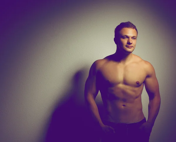 어두운 배경에 서 있는 건강 한 근육 질의 젊은 남자 — 스톡 사진