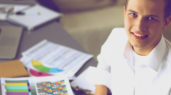 Young businessman with folder sitting in the office — Stock Photo, Image