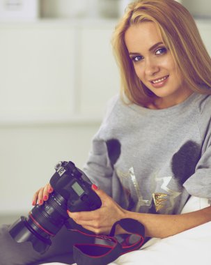 nő ül a kanapén házában a kamera