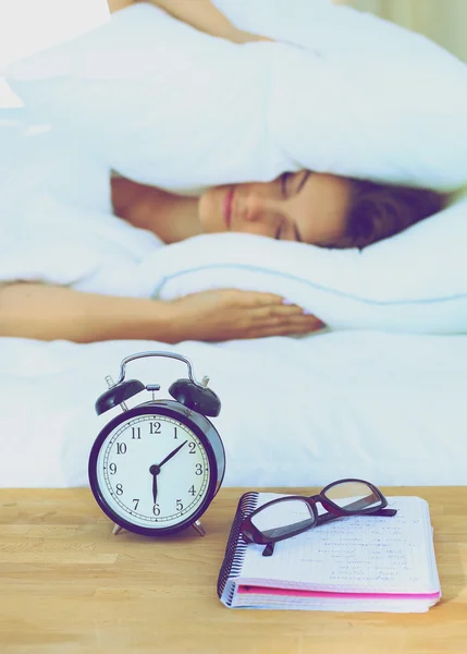 A young woman putting her alarm clock off in the morning — Stock Photo, Image