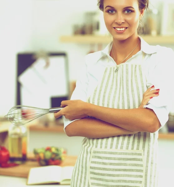 Uśmiechnięta młoda kobieta stojąca w kuchni — Zdjęcie stockowe