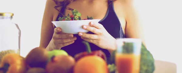 Flicka sitter i köket på skrivbord med frukt — Stockfoto