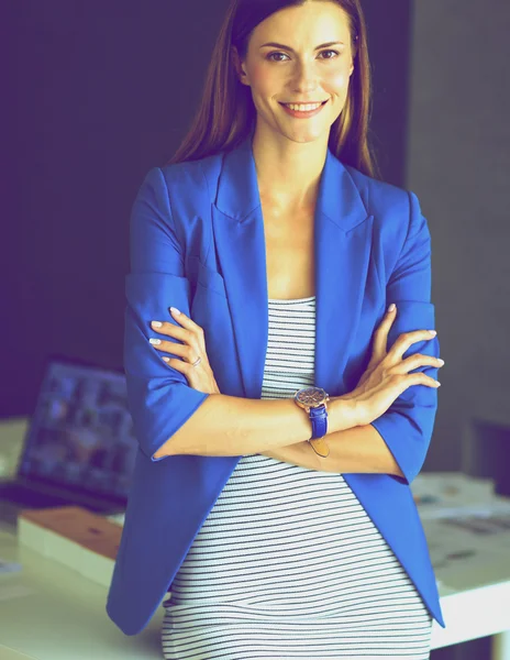 Porträt einer schönen Geschäftsfrau, die in der Nähe ihres Arbeitsplatzes steht — Stockfoto