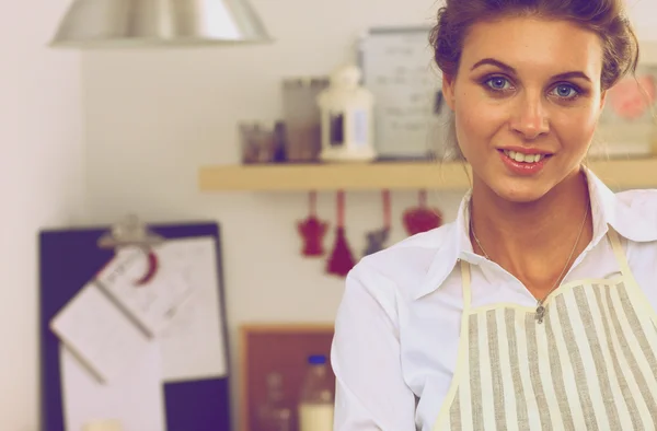 Mujer joven sonriente de pie en la cocina —  Fotos de Stock