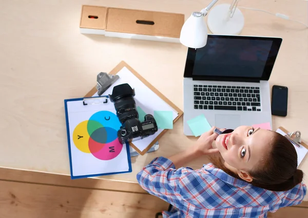 Kobieta fotograf siedzi na biurku z laptopem — Zdjęcie stockowe