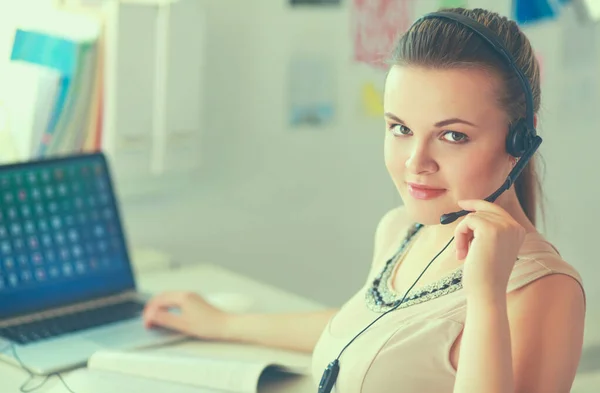 Retrato de mulher de negócios bonita trabalhando em sua mesa com fone de ouvido e laptop — Fotografia de Stock