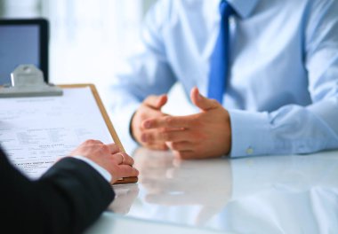 İş adamları iş toplantısında, ofiste oturup tartışıyorlar.