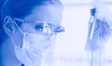 Modern laboratuvar veya hastanede plastik tıbbi tüplerle çalışan araştırmacı, doktor, bilim adamı veya laboratuvar asistanı