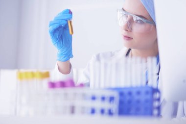 Laboratuvar asistanı bir kan örneğini analiz ediyor.