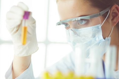 Modern laboratuvar veya hastanede plastik tıbbi tüplerle çalışan araştırmacı, doktor, bilim adamı veya laboratuvar asistanı