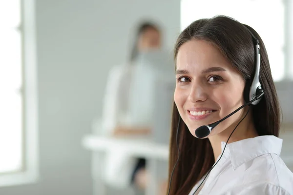 Mujer de negocios sonriente u operador de línea de ayuda con auriculares y computadora en la oficina —  Fotos de Stock
