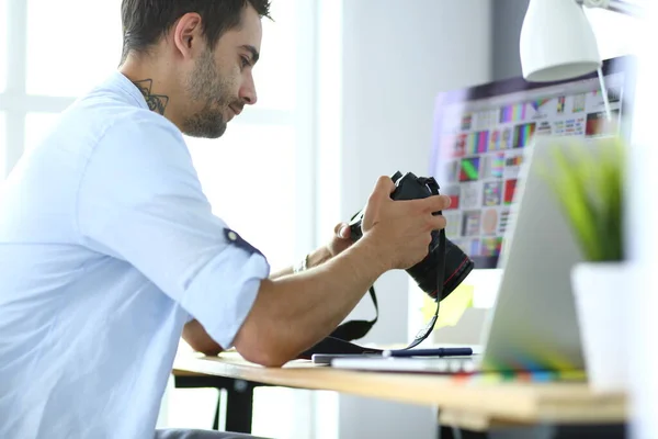 Retrato de jovem designer sentado no estúdio gráfico na frente de laptop e computador enquanto trabalhava online. — Fotografia de Stock