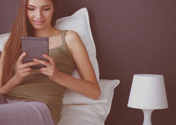 Vrouw die op de vloer zit met een digitale tablet — Stockfoto